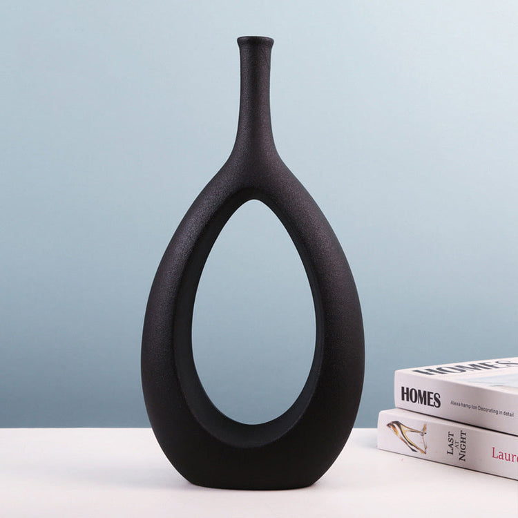 Modern ceramic vase with unique shape and floral arrangement, featuring a light luxury design for stylish home decoration.