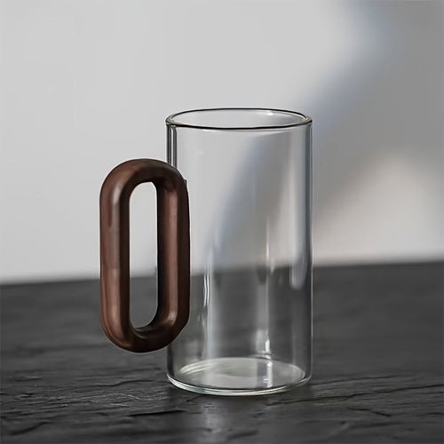 Clear glass mug with a wooden handle on a dark surface