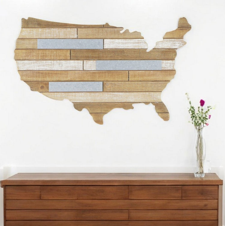Wooden wall art of the United States map on a white wall above a wooden cabinet.