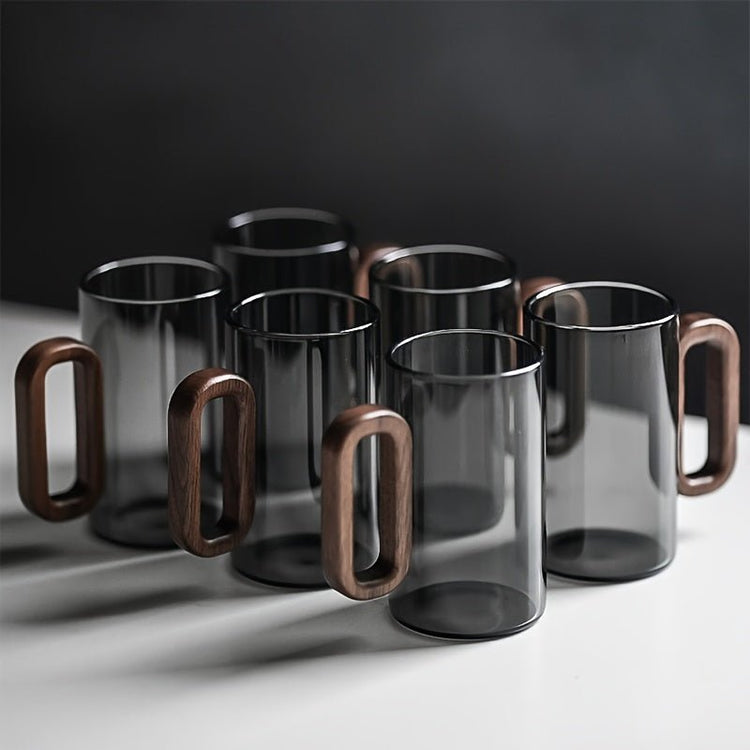 Set of glass mugs with wooden handles on a dark background