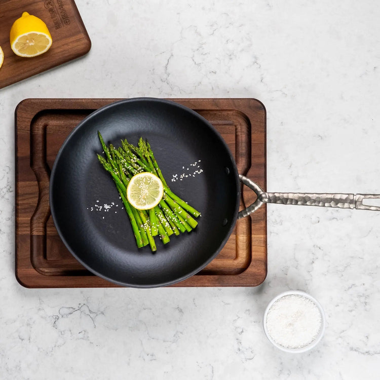 Alva Cookware frying pan with non-stick surface, stainless steel handle, shown on a stovetop ready for cooking.
