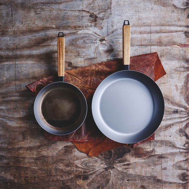 Alva Cookware frying pan with a non-stick surface, black handle, and stainless steel exterior, shown on a kitchen countertop.