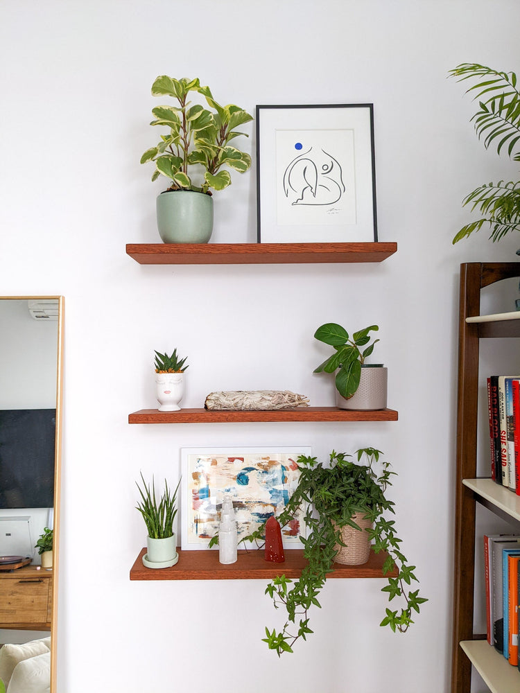 Natural oak floating wall shelf from NookWoodworking, 6 to 36 inches, minimalist design mounted on a wall with decorative items.