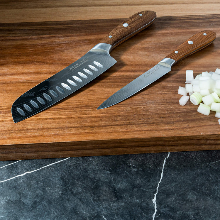 Swiss Diamond Damascus Santoku and paring knife set with wooden handles, neatly stacked on a clean surface.