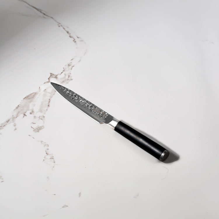 Swiss Diamond 5-inch hammered utility knife with a white marble handle, showcasing a sleek and durable kitchen knife design.