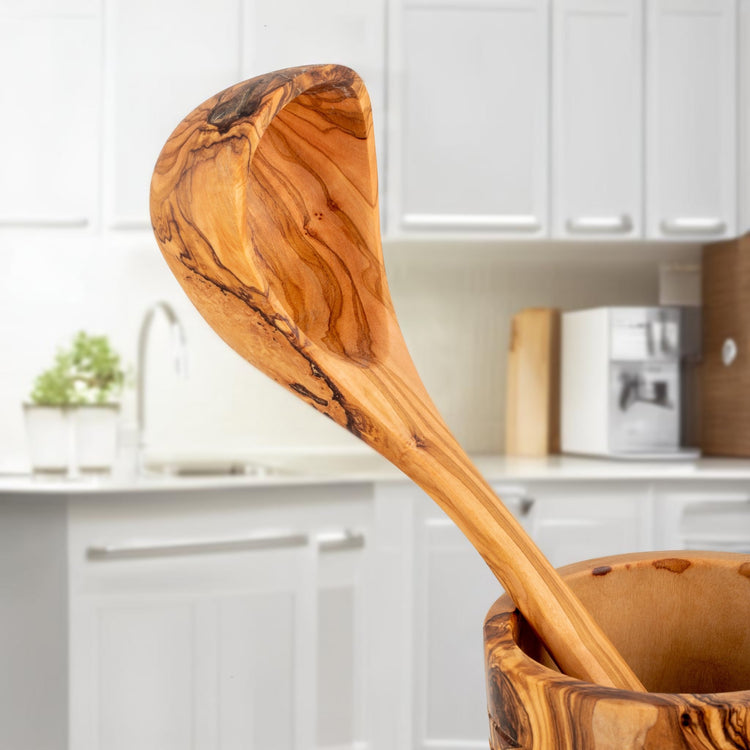 Wooden spoon in a wooden container with a kitchen background