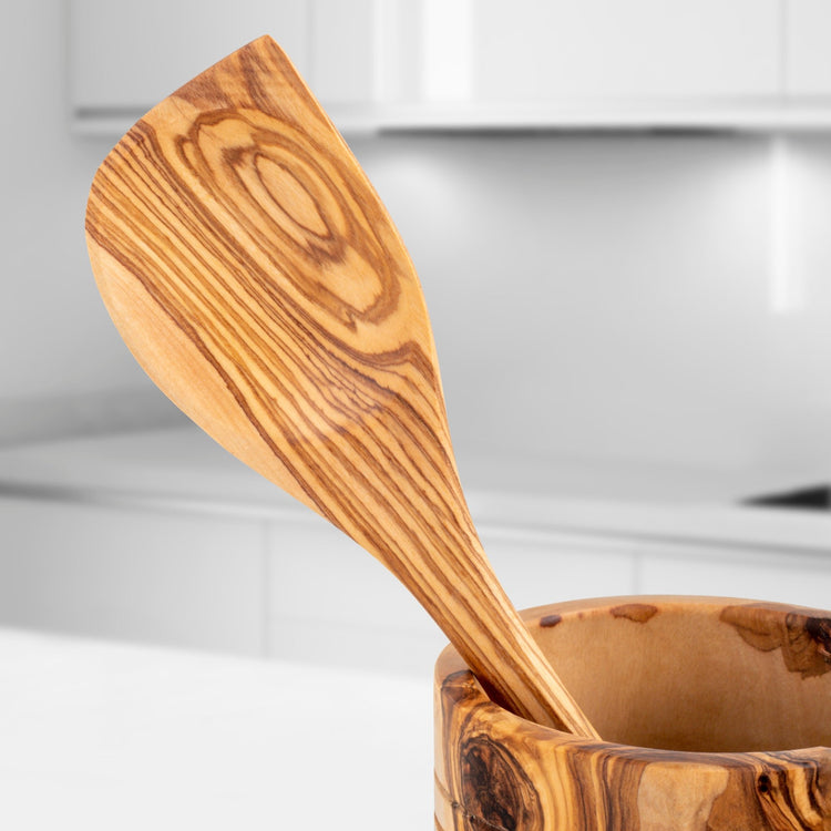 Wooden spoon in a wooden container with a blurred kitchen background