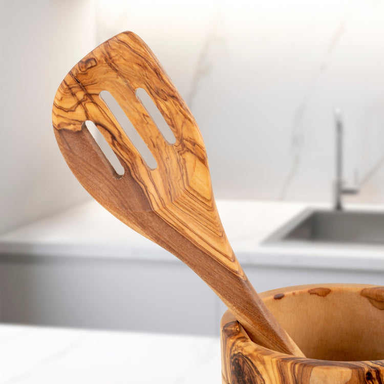 Wooden spatula with a wooden holder on a kitchen counter