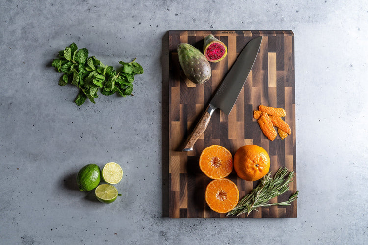Steelport Knife Co. everyday knife and cutting board set displayed on a kitchen countertop with knives and food.