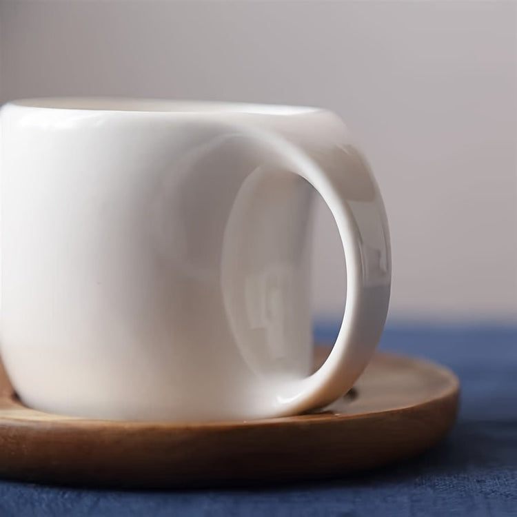 White ceramic cup on a wooden saucer with a blurred background