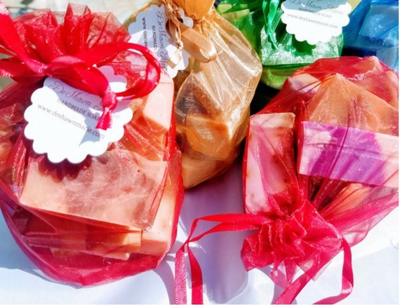 Colorful soap bars wrapped in cellophane with ribbons on a white background