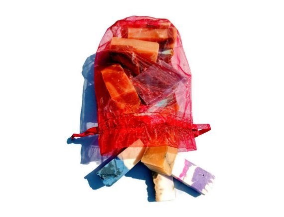 Colorful wooden blocks in a red mesh bag on a white background