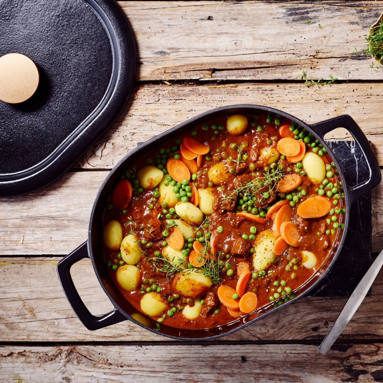 Alva Cookware 6 QT oval Dutch oven in black ceramic with sturdy handles and a glass lid for even cooking.