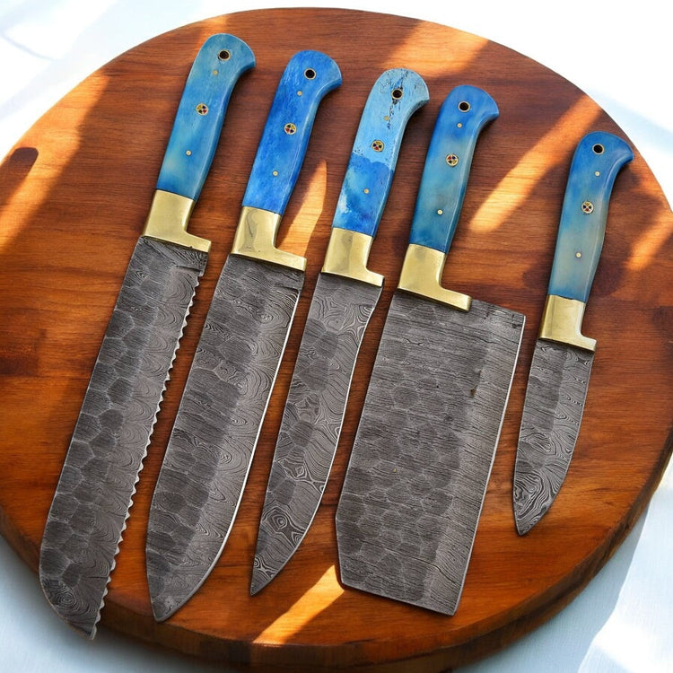 Handmade Damascus kitchen knives set with bone handles, showcasing polished blades and detailed craftsmanship.