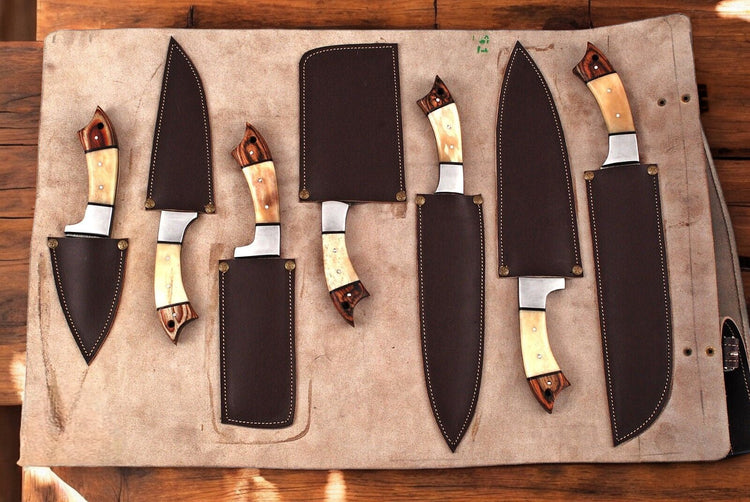 Handmade Damascus kitchen knives set with leather roll, featuring intricately patterned blades and secure leather storage.