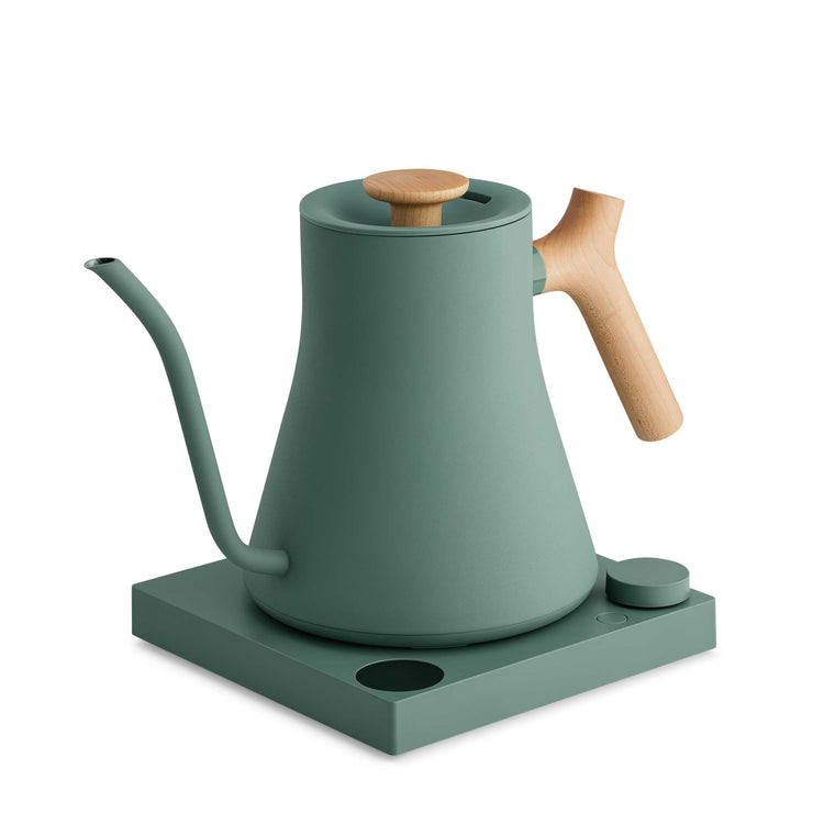 Fellow Stagg EKG Pro electric kettle in smoke green with maple handle, featuring a sleek modern design and digital temperature control.