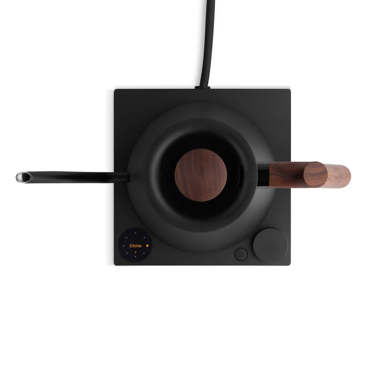 Fellow Stagg EKG Pro electric kettle with matte black finish and walnut handle, showcasing sleek design and digital display.