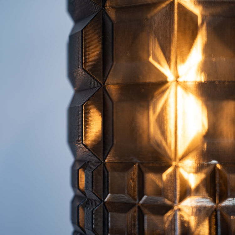 Wooj Design Gem Sconce featuring a modern geometric glass shade mounted on a sleek metal fixture.