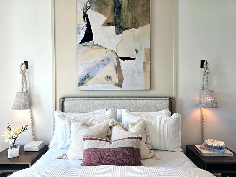 Modern luxury master bedroom with a gray upholstered platform bed, wood-paneled accent wall, built-in nightstands, and ambient pendant lighting.
