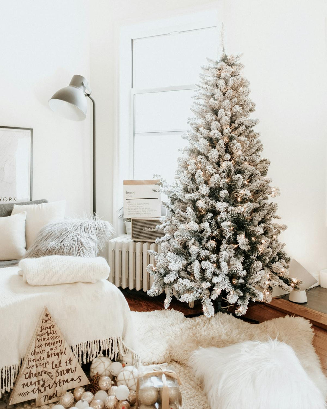 Modern living room with asymmetrical wall mirror reflecting twinkle lights and holiday decor