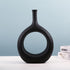 Elegant ceramic vase with a unique shape holding flower arrangement, modern luxury home decor from FLIPSTYLEZLLC.