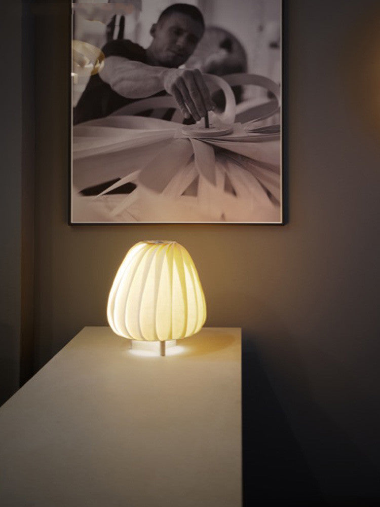 Modern minimalist FLIPSTYLEZLLC table lamp with sleek design, ideal for living room or bedroom decor, illuminated scene.