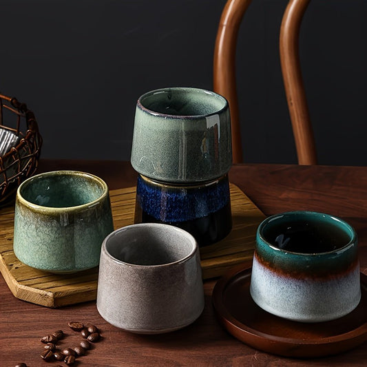 Set of ceramic cups on a wooden surface with coffee beans.