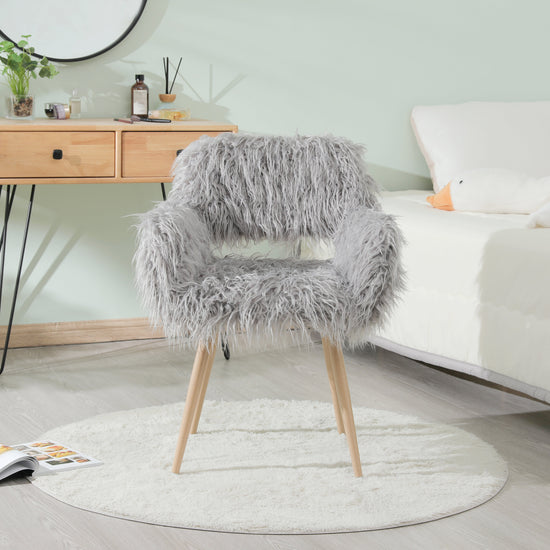 Grey faux fur upholstered dining chair with metal legs, modern and comfortable seating for dining rooms.