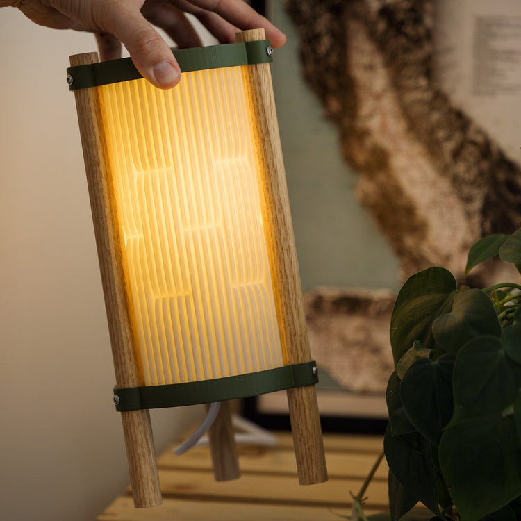 Terra Labs Toro table lamp with a sleek, modern design and a cylindrical white shade on a wooden base.