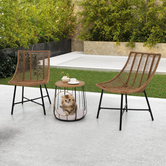 Two wicker chairs with a small table featuring a cat in a pet carrier on a patio.