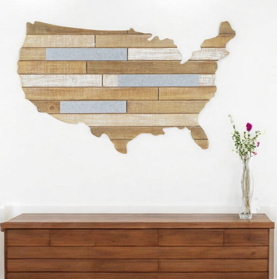 Wooden wall art of the United States map on a white wall above a wooden cabinet.