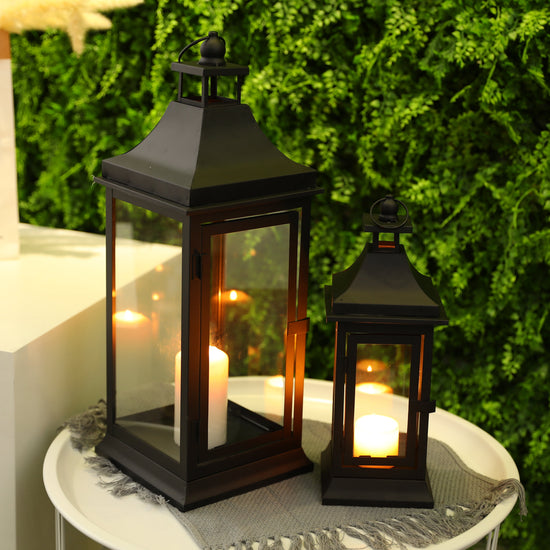 Set of two JHY DESIGN outdoor decorative candle lanterns, 13 and 19.5 inches tall with glass panels and metal frames.