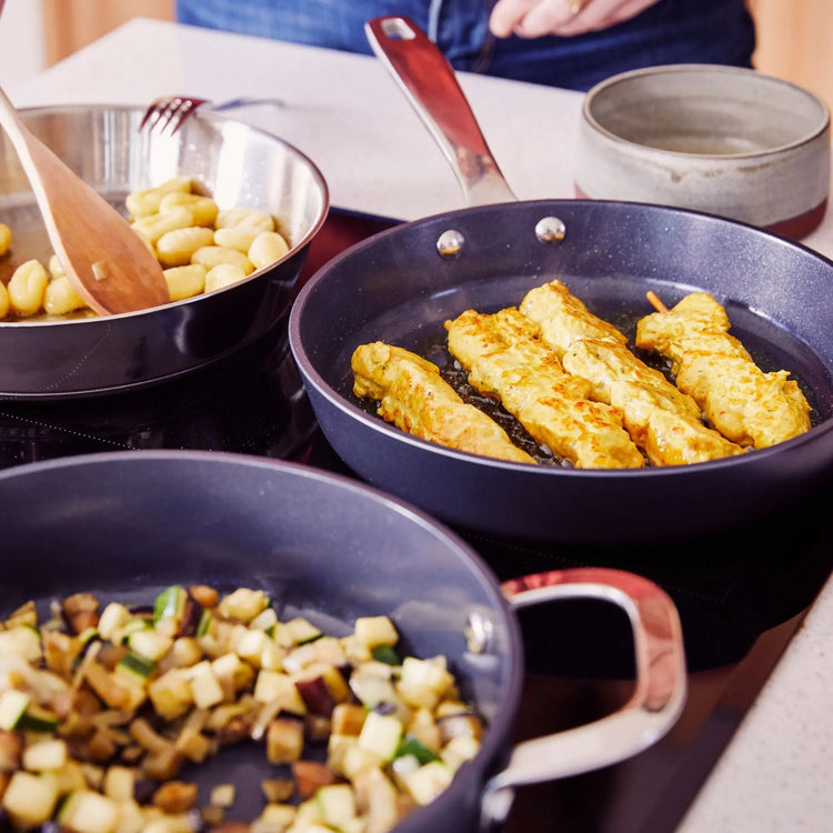 Alva Cookware 5-piece cookware set with pots, pans, and lids, displayed on a kitchen countertop in the image.