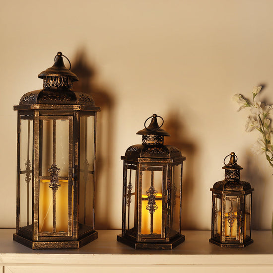 Set of 3 large outdoor metal and glass candle lanterns for patio decor, featuring decorative design and candle holders.