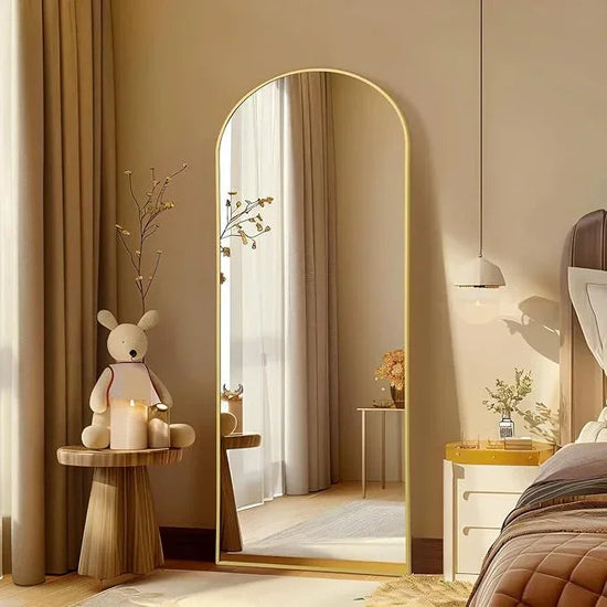 Large arched floor mirror with gold frame by MIRRORONS, full-length design for bedroom, living room, or gym use.
