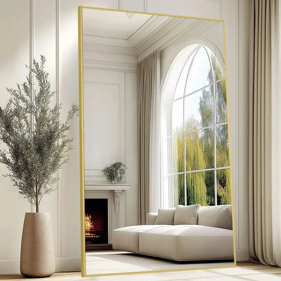 Oversized freestanding arched floor mirror with full-length gold aluminum frame, showcasing a sleek, modern design.