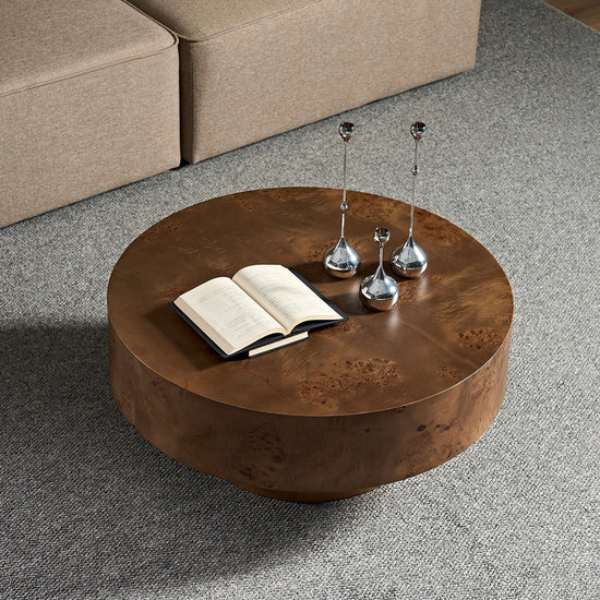 Round coffee table with burl wood veneer surface and walnut pedestal base, modern design for living room decor.