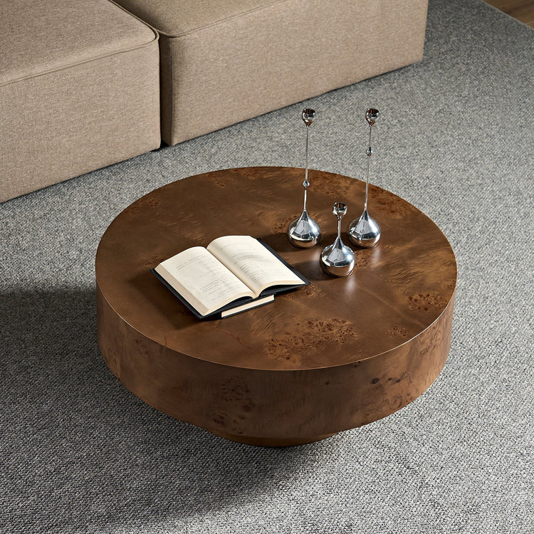 Round coffee table with burl wood veneer surface and walnut pedestal base, modern design for living room decor.