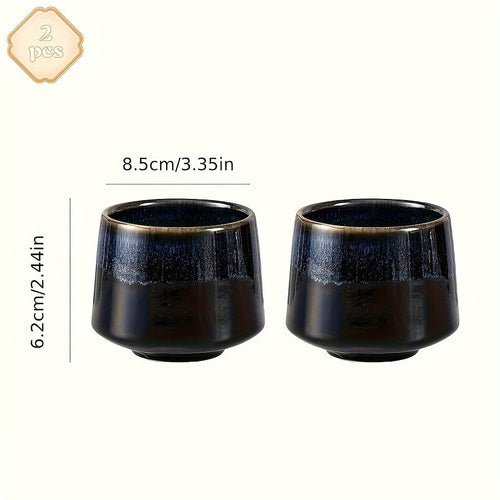 Two black ceramic cups with gold rims on a white background, showing dimensions.