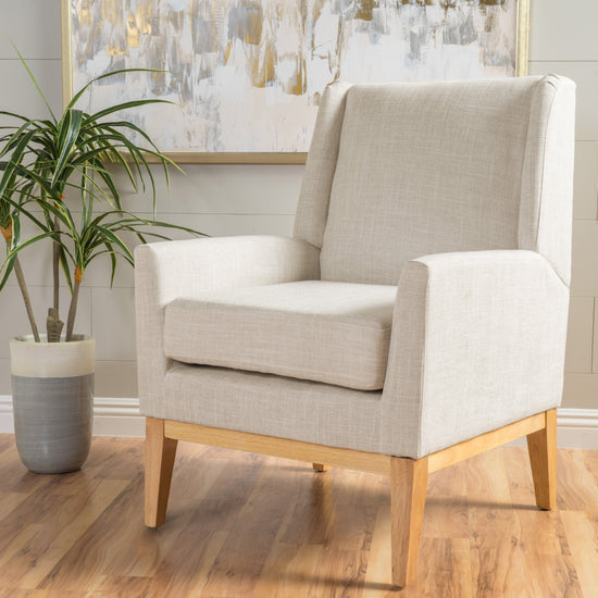 Beige mid-century modern accent chair with padded cushion seat for home or office, featuring sleek design and comfortable fabric upholstery.