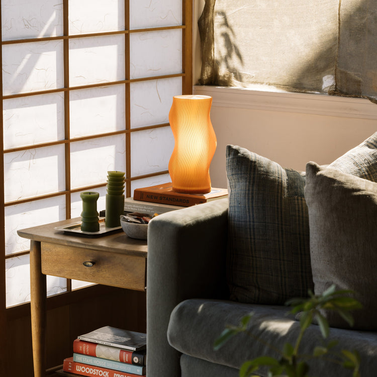 Terra Labs Woogie Table Lamp with a modern, playful design, featuring a smooth, rounded base and soft glowing light.