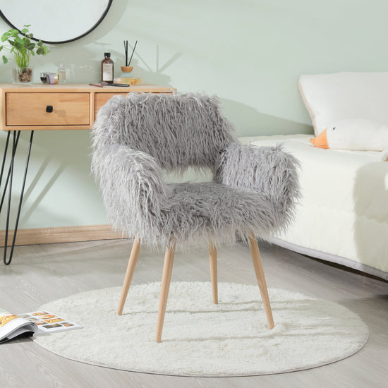 Grey faux fur upholstered dining chair with metal legs, modern design and plush seating for dining and living spaces.