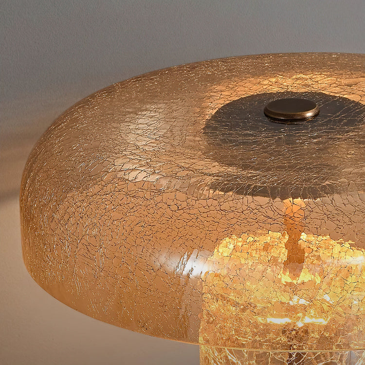 Mooiehome Eira Crackle Table Lamp with textured glass base and fabric shade, placed on a wooden side table in a cozy living room setting.
