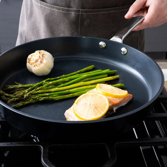 Alva Cookware 5-piece cookware set includes frying pan, pots, and lids, all with stainless steel handles and non-stick surfaces.