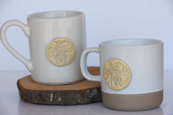 Ceramic bee-shaped mug with a yellow and black design, featuring a detailed bee illustration on the side.