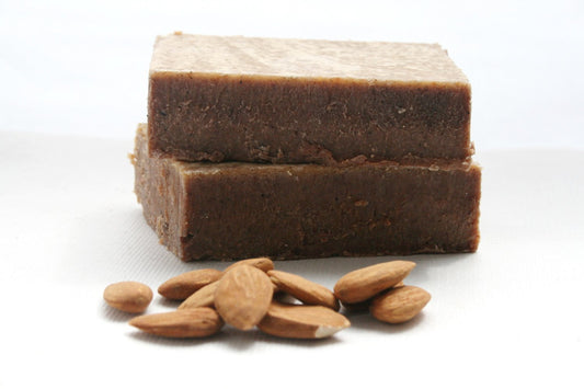 Two bars of brown soap with almonds on a white background