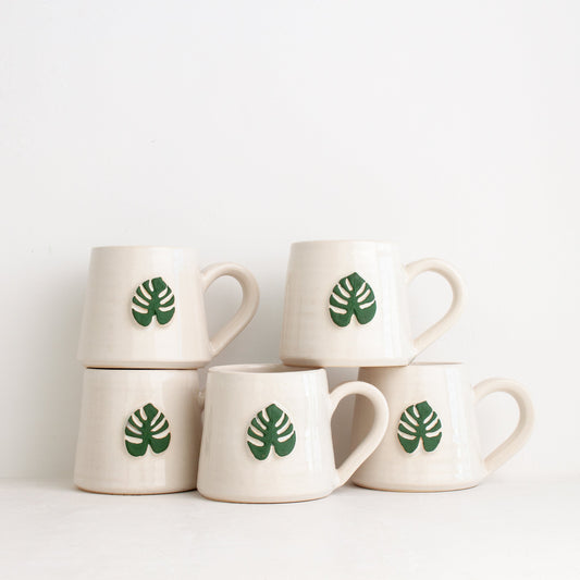 Black Oak Art Monstera Mug featuring a vibrant monstera leaf design, perfect for plant lovers and coffee enthusiasts.