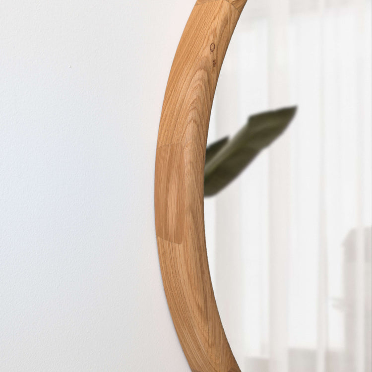 VARBROS THE KOLO wall mirror with a sleek, modern design reflecting natural light in a contemporary room setting.
