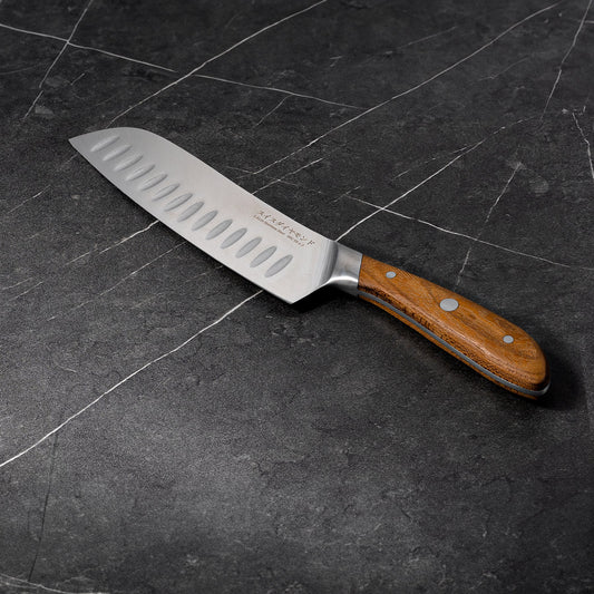 Swiss Diamond 7-inch Damascus Santoku Knife with a sharp, patterned blade and ergonomic handle for precise slicing and chopping.