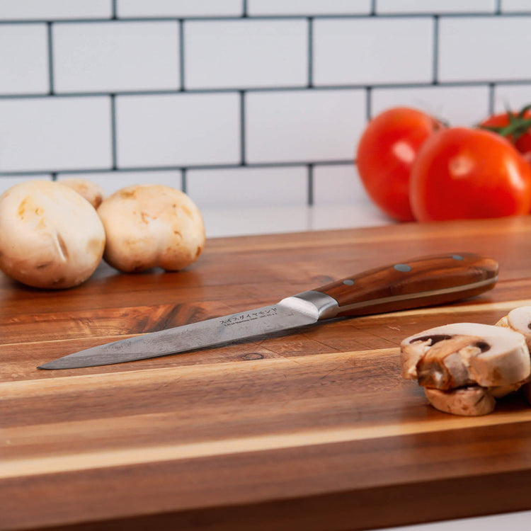 Swiss Diamond 5-inch Damascus utility knife with a textured blade and ergonomic handle, ideal for precise cutting tasks.
